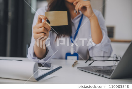 .Women holding credit card and using smartphones at home.Online shopping, internet banking, store online, payment, spending money, e-commerce payment at the store, credit card, concept .Women holding credit card and using smartphones at home.Online shopping, internet banking, store online, payment, spending money, e-commerce payment at the store, credit card, concept 110085848
