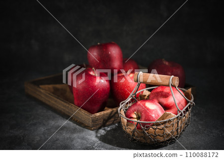 red apples in a wicker basket on dark background red apples in a wicker basket on dark background 110088172