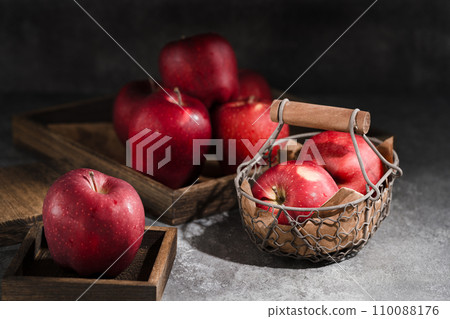 red apples in a wicker basket on dark background 110088176
