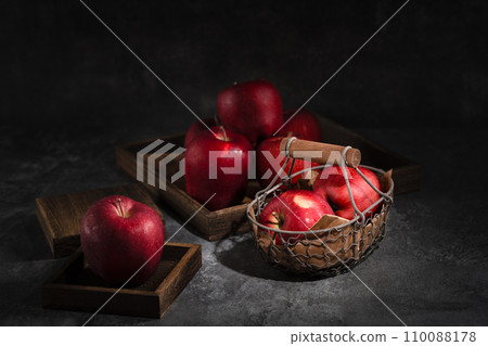 red apples in a wicker basket on dark background 110088178