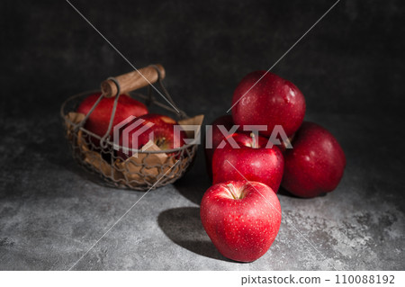 red apples in a wicker basket on dark background red apples in a wicker basket on dark background 110088192