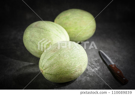 Fresh honeydew melon on dark background Fresh honeydew melon on dark background 110089839
