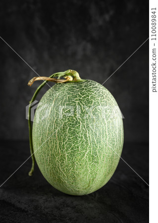 Fresh honeydew melon on dark background Fresh honeydew melon on dark background 110089841