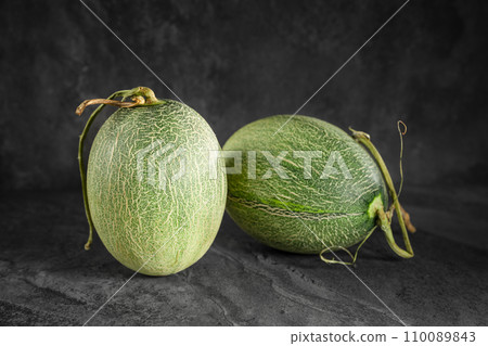 Fresh honeydew melon on dark background Fresh honeydew melon on dark background 110089843