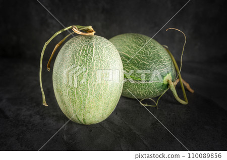 Fresh honeydew melon on dark background Fresh honeydew melon on dark background 110089856