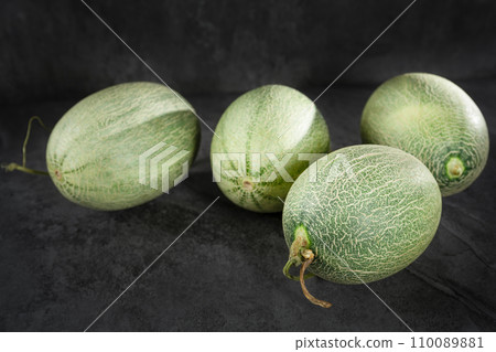 Fresh honeydew melon on dark background Fresh honeydew melon on dark background 110089881