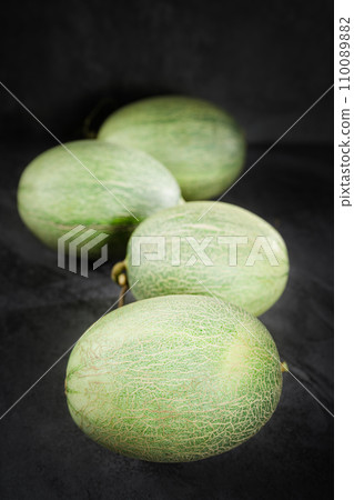 Fresh honeydew melon on dark background Fresh honeydew melon on dark background 110089882