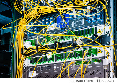 fiber optic cables plugged in network switch panels inside data center 110090024
