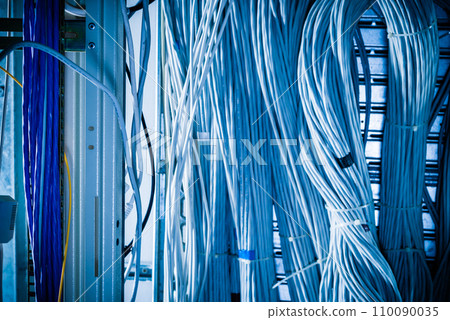detail of large number of ethernet cables tied together connecting racks inside server room 110090035