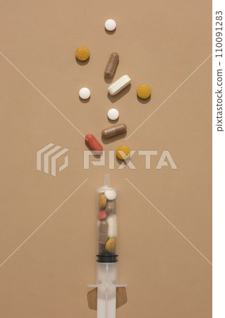 The pills are contained in a syringe on a brown background. The medicine has curative and inhibitory effects to limit the severity of the disease. 110091283