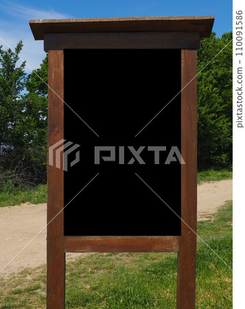 Blank black vertical rectangular pylon stand on forest dirt road mock up. Empty panel for advertisement, promotion mockup. Clear canvas frame banner for company advert template. Fruska Gora Serbia. 110091586