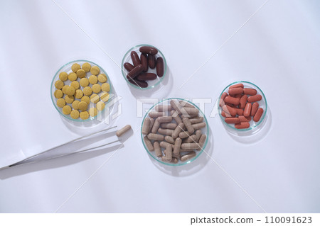 Each petri dish displays each drug in a different color and shape on a white background. Supplement vitamins and nutrients from functional foods. 110091623