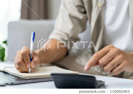 Man is calculating annual tax with calculator and filling form of Individual Income Tax Return. Season to pay Tax and Budget planning concept. Man is calculating annual tax with calculator and filling form of Individual Income Tax Return. Season to pay Tax and Budget planning concept. 110092063