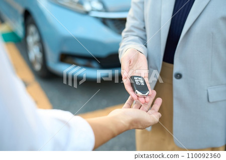Woman handing over car keys outside Woman handing over car keys outside 110092360