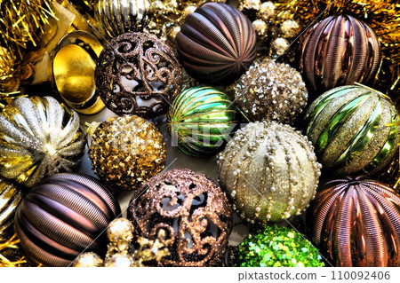 New Year's Christmas balls, tinsel and decorations close up. A lot of decoration of golden, brown, yellow, green. Striped Christmas balls. Festive beautiful colorful background. Home holidays design. New Year's Christmas balls, tinsel and decorations close up. A lot of decoration of golden, brown, yellow, green. Striped Christmas balls. Festive beautiful colorful background. Home holidays design. 110092406