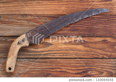 the old garden tools saw on a wooden table the old garden tools saw on a wooden table 110093038