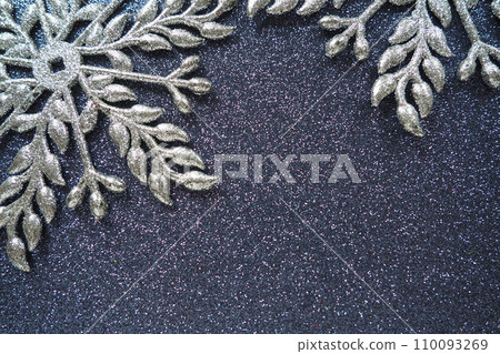 Two large silver flat ornate snowflakes are laid out on velvety black paper. Free space for text. New Year or Christmas background for advertising. Festive winter flat lay. Beautiful snowflake. 110093269