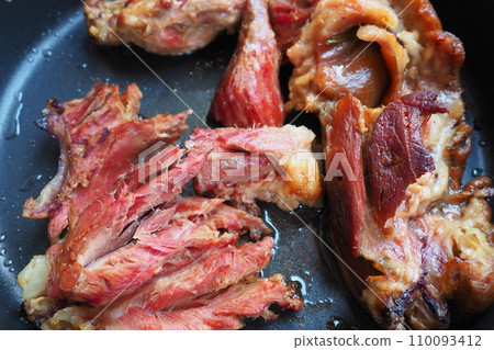 Roasted smoked pork shoulder or knee. Delicious meat on a black baking sheet with drops of vegetable oil, taken out of the oven. Pork delicacy for dinner in a restaurant and family lunch. Red meat Roasted smoked pork shoulder or knee. Delicious meat on a black baking sheet with drops of vegetable oil, taken out of the oven. Pork delicacy for dinner in a restaurant and family lunch. Red meat 110093412