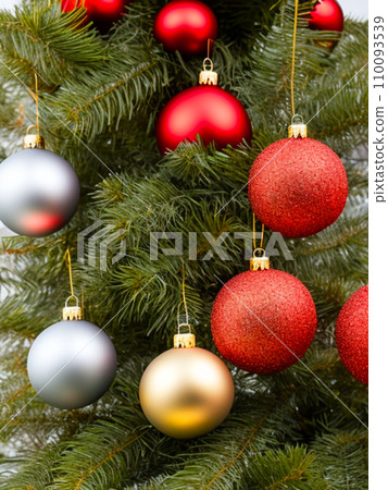 Beautiful red, gold, silver, yellow, beige shiny and matte Christmas balls shine on a spruce branch. Happy New Year. Merry Christmas. Christmas background - baubles and branch of spruce tree. Beautiful red, gold, silver, yellow, beige shiny and matte Christmas balls shine on a spruce branch. Happy New Year. Merry Christmas. Christmas background - baubles and branch of spruce tree. 110093539