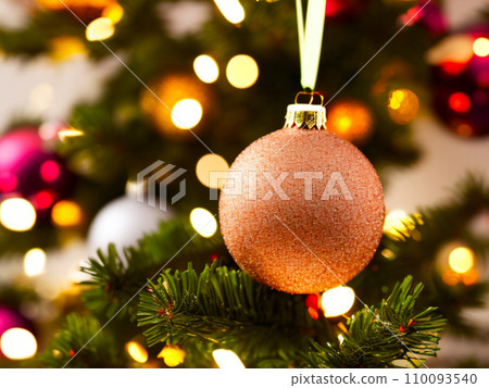 Beautiful red, gold, silver, yellow, beige shiny and matte Christmas balls shine on a spruce branch. Happy New Year. Merry Christmas. Christmas background - baubles and branch of spruce tree. 110093540