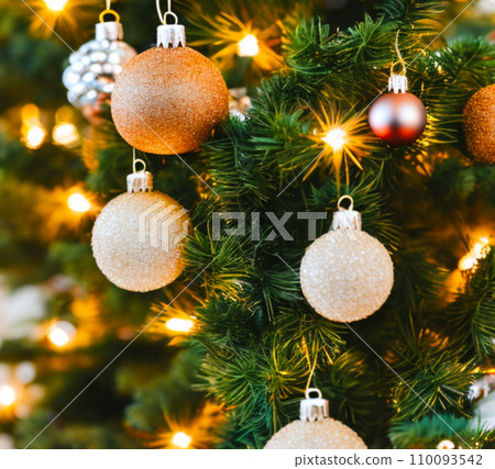 Beautiful red, gold, silver, yellow, beige shiny and matte Christmas balls shine on a spruce branch. Happy New Year. Merry Christmas. Christmas background - baubles and branch of spruce tree. Beautiful red, gold, silver, yellow, beige shiny and matte Christmas balls shine on a spruce branch. Happy New Year. Merry Christmas. Christmas background - baubles and branch of spruce tree. 110093542