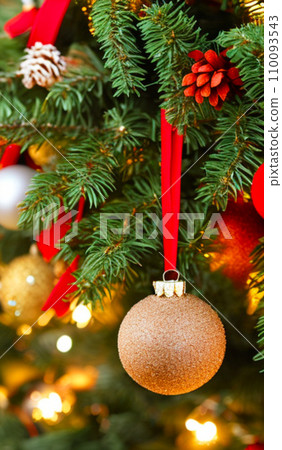 Beautiful red, gold, silver, yellow, beige shiny and matte Christmas balls shine on a spruce branch. Happy New Year. Merry Christmas. Christmas background - baubles and branch of spruce tree. Beautiful red, gold, silver, yellow, beige shiny and matte Christmas balls shine on a spruce branch. Happy New Year. Merry Christmas. Christmas background - baubles and branch of spruce tree. 110093543