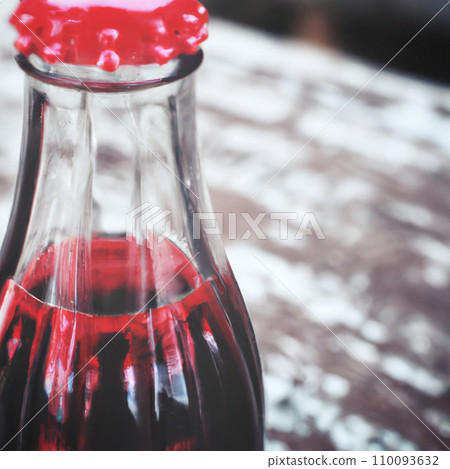 A bottle of dark liquid with a red metallic aluminum stopper on a wooden background. Copyspace. Free space for an inscription. Picture generated by AI A bottle of dark liquid with a red metallic aluminum stopper on a wooden background. Copyspace. Free space for an inscription. Picture generated by AI 110093632