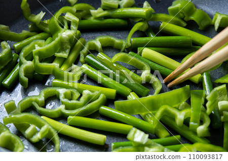 煎鍋裡煎青椒、蒜苗的烹飪場景。 煎鍋裡煎青椒、蒜苗的烹飪場景。 110093817