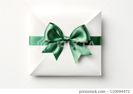 White gift box tied with green ribbon and bow on white background 110094472
