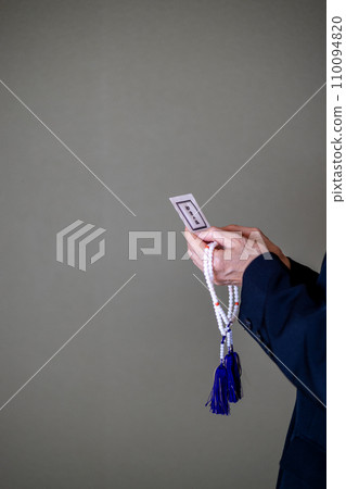 葬禮結束後，一位婦女的手拿著念珠和淨化鹽。 110094820