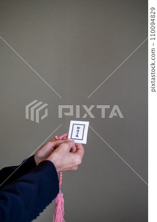 A woman's hands after a funeral, holding rosary beads and purifying salt. A woman's hands after a funeral, holding rosary beads and purifying salt. 110094829