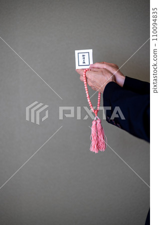 葬禮結束後,一位婦女的手拿著念珠和淨化鹽。 葬禮結束後,一位婦女的手拿著念珠和淨化鹽。 110094835