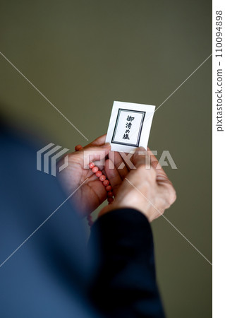 A woman's hands after a funeral, holding rosary beads and purifying salt. A woman's hands after a funeral, holding rosary beads and purifying salt. 110094898