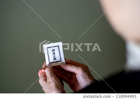 葬禮結束後，一名婦女手持念珠和淨化鹽 110094991