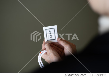 葬禮結束後，一名婦女手持念珠和淨化鹽 110094995