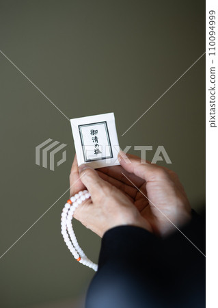 葬禮結束後,一位婦女的手拿著念珠和淨化鹽。 葬禮結束後,一位婦女的手拿著念珠和淨化鹽。 110094999