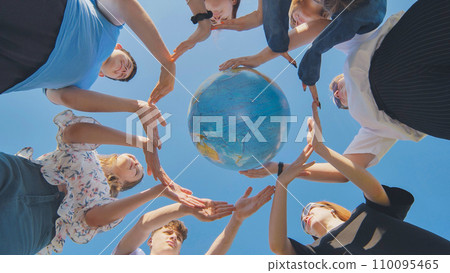 Students make a circle around the globe of the world. The concept of world peace. 110095465