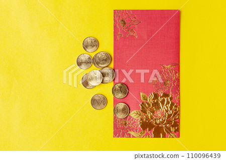Top view of Chinese New Year red packets on yellow cover background. Customizable space for text. 110096439