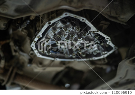 Close-up of a car's CVT gearbox on a lift. Close-up of a car's CVT gearbox on a lift. 110096910