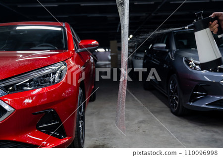 The master prepares the vinyl film before applying it to the car. 110096998