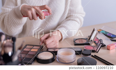 Close-up of makeup artist's hands among cosmetics. Close-up of makeup artist's hands among cosmetics. 110097210
