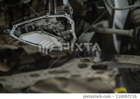 Replacing the gearbox oil prefilter. Car on a lift in a car service center. Replacing the gearbox oil prefilter. Car on a lift in a car service center. 110097216