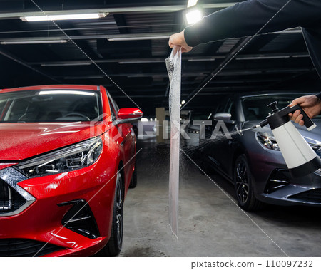 The master prepares the vinyl film before applying it to the car. The master prepares the vinyl film before applying it to the car. 110097232