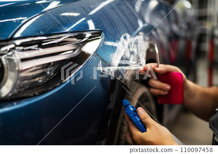 The master in the car service applies an armor film to the car. The master in the car service applies an armor film to the car. 110097458