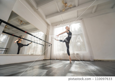 A beautiful Asian woman is dancing at the barre. Ballet dancer. 110097633
