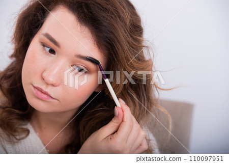 Portrait of a Caucasian young woman doing makeup.  110097951