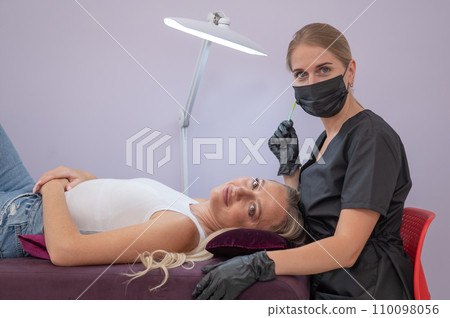 Caucasian woman on eyelash extension procedure. Caucasian woman on eyelash extension procedure. 110098056