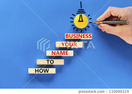 How to name your business symbol. Concept words How to name your business on wooden blocks. Beautiful blue table blue background. Businessman hand. How to name your business concept. Copy space. How to name your business symbol. Concept words How to name your business on wooden blocks. Beautiful blue table blue background. Businessman hand. How to name your business concept. Copy space. 110098329