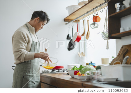 一名30多歲的男子在廚房做飯 110098683