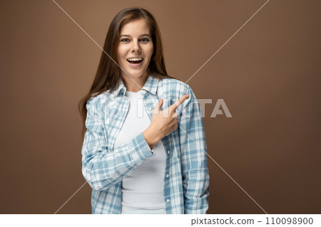 Headshot portrait of a young European woman with brown hair in a casual look 110098900